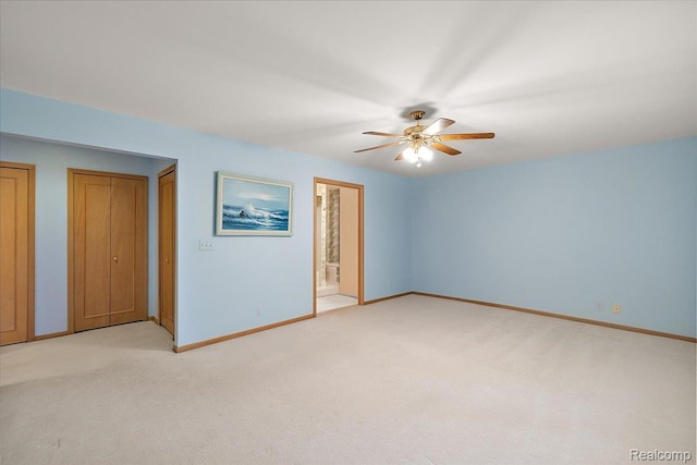 55728 Lorraine Dr Unit 20, Utica, MI 48316 - unfurnished bedroom featuring light colored carpet, two closets, ensuite bath, and ceiling fan