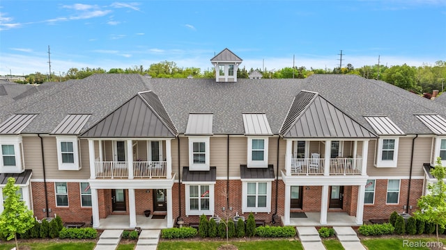 164 Jotham Ave, Auburn Hills, MI 48326 - view of front of house featuring a standing seam roof, a balcony, brick siding, and a metal roof