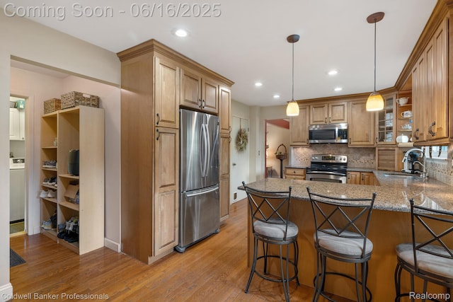 3184 Cedar Key Dr, Lake Orion, MI 48360 - kitchen featuring appliances with stainless steel finishes, light wood-type flooring, backsplash, a peninsula, and a kitchen breakfast bar