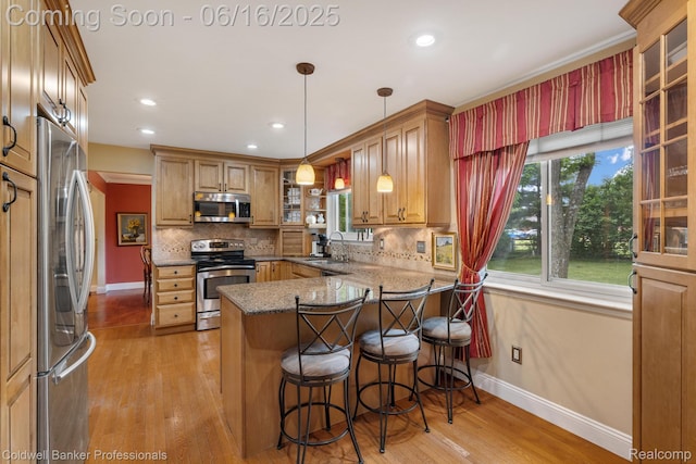 3184 Cedar Key Dr, Lake Orion, MI 48360 - kitchen with appliances with stainless steel finishes, a peninsula, light wood-type flooring, tasteful backsplash, and recessed lighting