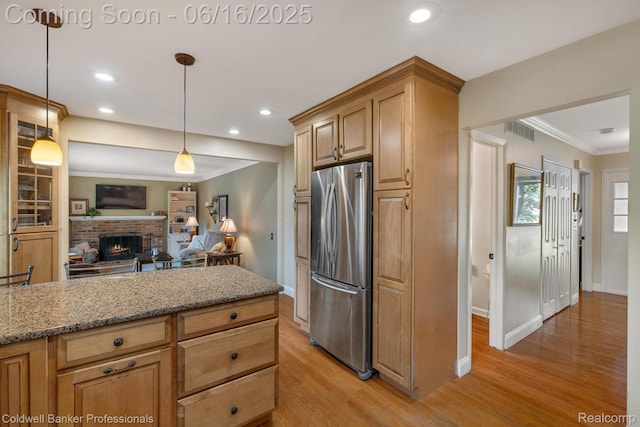 3184 Cedar Key Dr, Lake Orion, MI 48360 - kitchen with freestanding refrigerator, light wood-style flooring, light stone counters, ornamental molding, and open floor plan