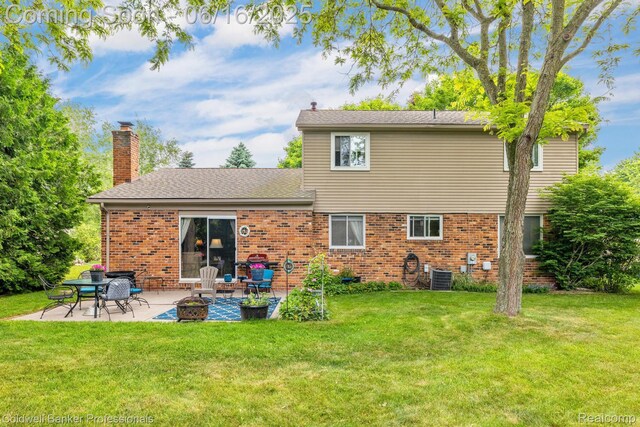 3184 Cedar Key Dr, Lake Orion, MI 48360 - rear view of house featuring a patio, a yard, and brick siding