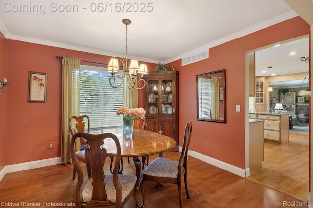 3184 Cedar Key Dr, Lake Orion, MI 48360 - dining area with light wood-type flooring, a chandelier, and crown molding