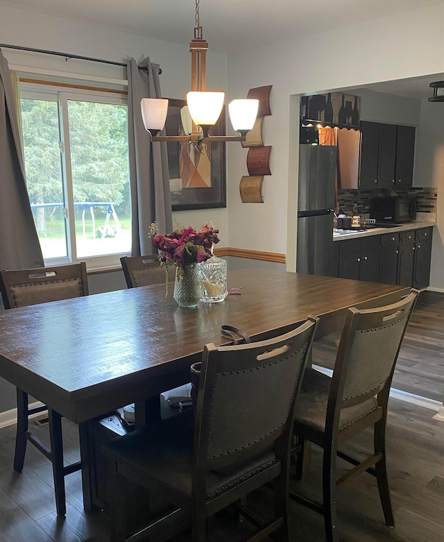4236 Marianne Dr, Flushing, MI 48433 - dining space featuring healthy amount of natural light, dark wood-style floors, and a chandelier