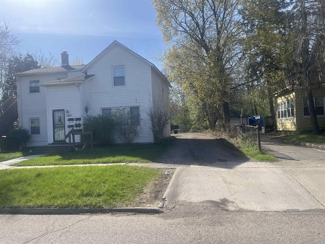 1021 2nd St, Flint, MI 48503 - view of front of property with driveway, a chimney, and a front yard