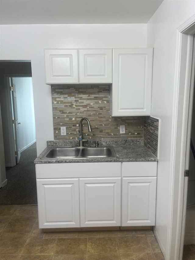 1021 2nd St, Flint, MI 48503 - kitchen featuring white cabinetry, decorative backsplash, and dark countertops