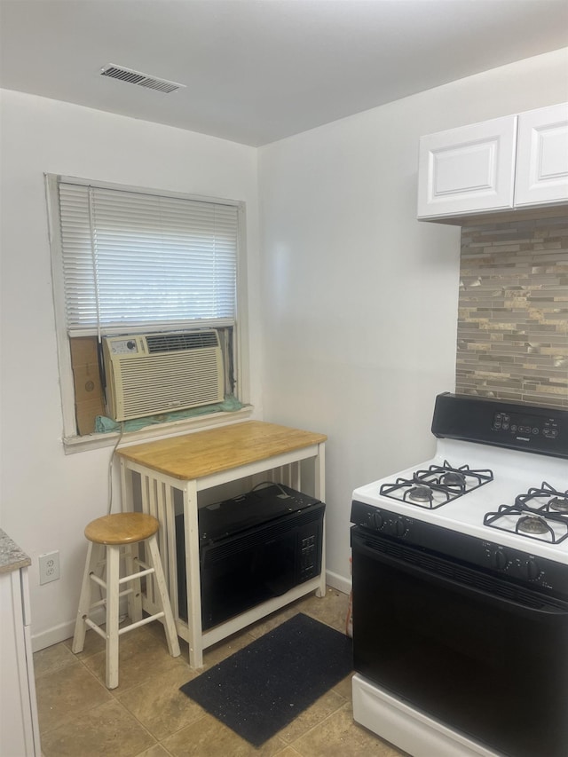 1021 2nd St, Flint, MI 48503 - kitchen with range with gas cooktop, white cabinetry, and light tile patterned floors