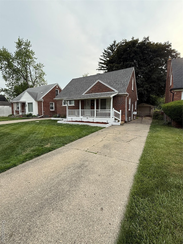 11735 Braile St, Detroit, MI 48228 - view of front of home with covered porch, brick siding, a front lawn, an outdoor structure, and concrete driveway