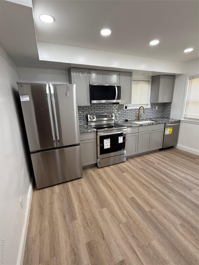 11735 Braile St, Detroit, MI 48228 - kitchen featuring stainless steel appliances, gray cabinets, light wood-style flooring, decorative backsplash, and recessed lighting