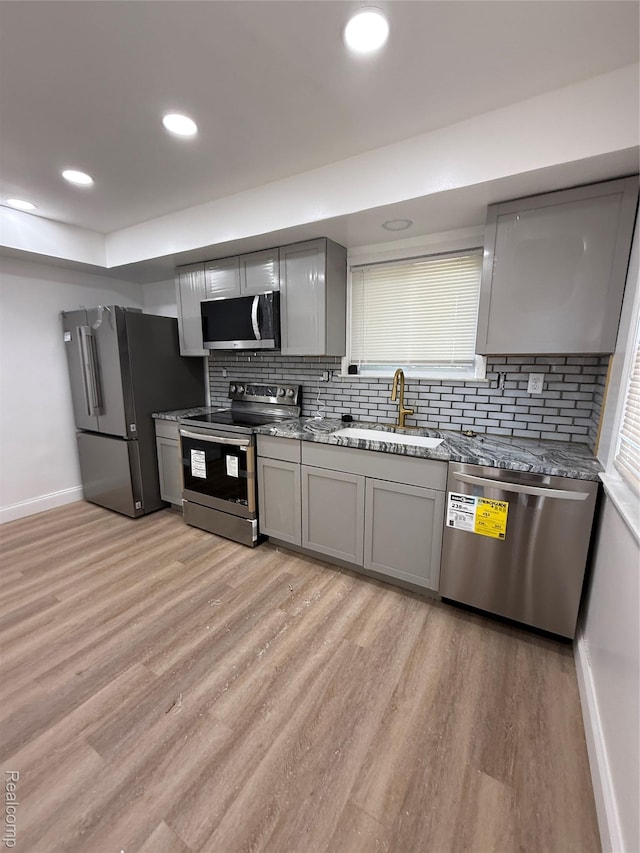 11735 Braile St, Detroit, MI 48228 - kitchen with stainless steel appliances, gray cabinetry, light wood-style flooring, decorative backsplash, and light stone counters