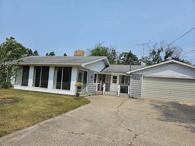 1363 Swain St, White Cloud, MI 49349 - ranch-style house with a chimney, a garage, concrete driveway, a front lawn, and a shingled roof