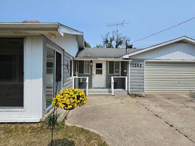 1363 Swain St, White Cloud, MI 49349 - view of front of home with an attached garage, driveway, and covered porch