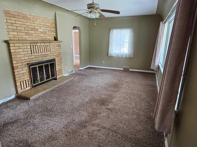 1363 Swain St, White Cloud, MI 49349 - unfurnished living room featuring a ceiling fan, carpet flooring, arched walkways, and a brick fireplace