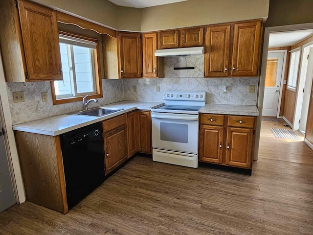 1363 Swain St, White Cloud, MI 49349 - kitchen with white electric range, black dishwasher, under cabinet range hood, and brown cabinetry