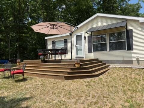 5814 N Trails End Dr, Irons, MI 49644 - back of house featuring a deck and a yard