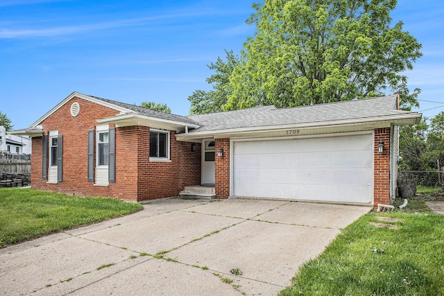 1709 Tuscany Ln, Holt, MI 48842 - view of front of home with brick siding, driveway, an attached garage, and roof with shingles