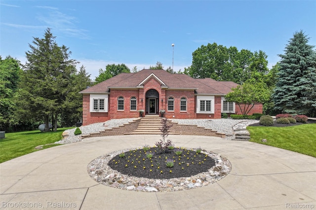 6439 Cohoctah Rd, Fenton, MI 48430 - view of front facade featuring brick siding, curved driveway, and a front lawn
