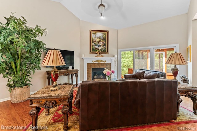 6439 Cohoctah Rd, Fenton, MI 48430 - living room with wood finished floors, vaulted ceiling, and a glass covered fireplace