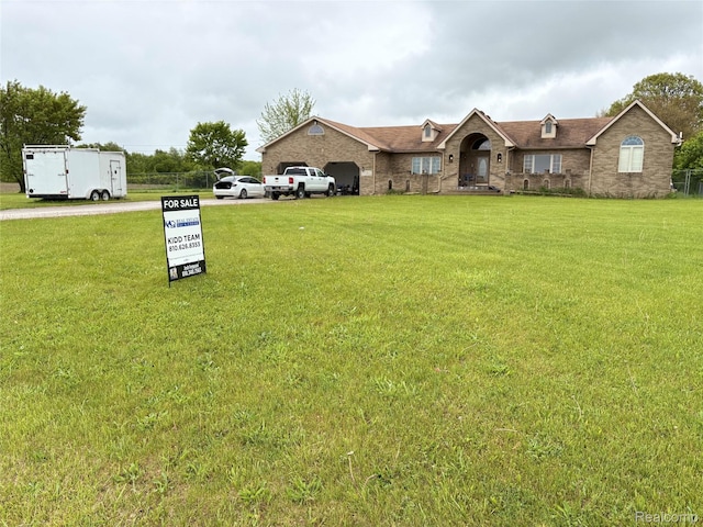 3351 Reid Rd, Swartz Creek, MI 48473 - view of front of house featuring a front yard, a garage, and brick siding