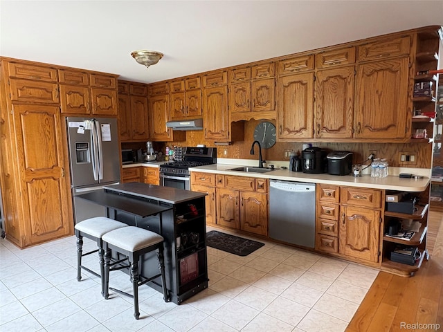 3351 Reid Rd, Swartz Creek, MI 48473 - kitchen featuring stainless steel appliances, under cabinet range hood, open shelves, and brown cabinets