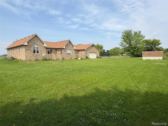 3351 Reid Rd, Swartz Creek, MI 48473 - rear view of property with a yard, a garage, and brick siding