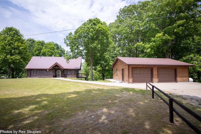 4585 W Arrowhead Dr, White Cloud, MI 49349 - view of front facade featuring a garage, a front lawn, an outbuilding, and a metal roof