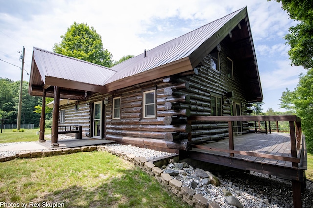 4585 W Arrowhead Dr, White Cloud, MI 49349 - view of side of home featuring a deck, a lawn, a metal roof, log siding, and a patio