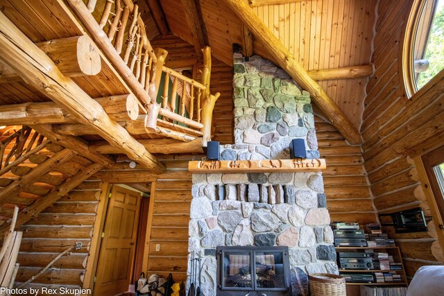 4585 W Arrowhead Dr, White Cloud, MI 49349 - unfurnished living room with rustic walls, beamed ceiling, plenty of natural light, and a stone fireplace