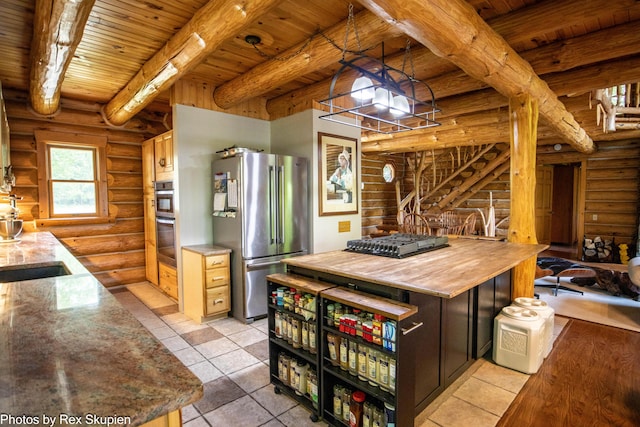 4585 W Arrowhead Dr, White Cloud, MI 49349 - kitchen featuring stainless steel appliances, a wood ceiling with exposed beams, rustic walls, light tile patterned floors, and pendant lighting