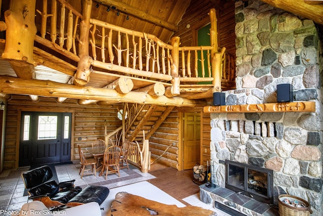 4585 W Arrowhead Dr, White Cloud, MI 49349 - unfurnished living room featuring log walls, high vaulted ceiling, a wood ceiling with exposed beams, and a stone fireplace