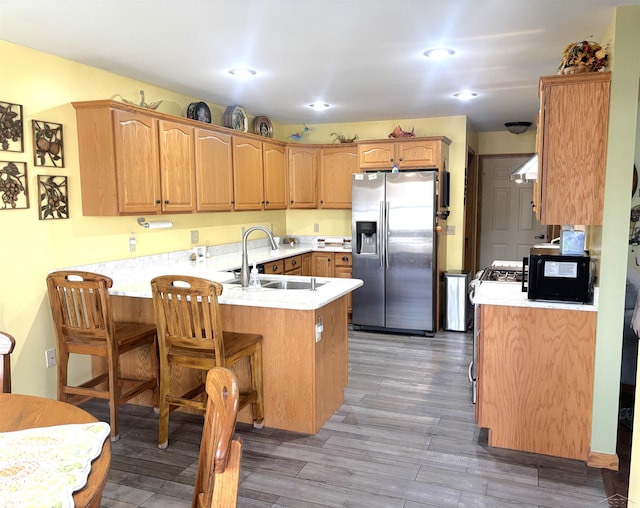 3004 Mackinaw Meadows Dr, Saginaw, MI 48603 - kitchen featuring stainless steel fridge with ice dispenser, a peninsula, gas range oven, wall chimney range hood, and light wood-style flooring