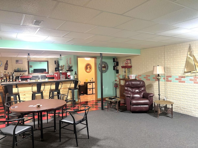 3004 Mackinaw Meadows Dr, Saginaw, MI 48603 - dining space with brick wall, a bar, carpet flooring, and a paneled ceiling