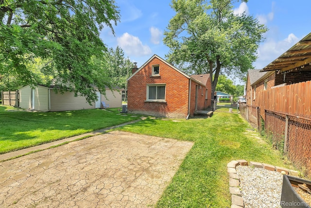 5941 Ziegler St, Taylor, MI 48180 - back of house with brick siding, a chimney, an outdoor structure, and a patio