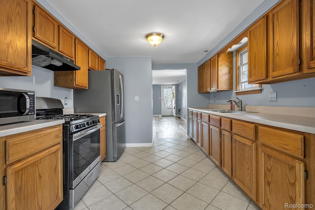 5941 Ziegler St, Taylor, MI 48180 - kitchen featuring stainless steel appliances, under cabinet range hood, light countertops, light tile patterned floors, and brown cabinets