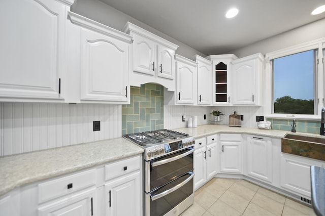 874 Pinecrest, Dexter, MI 48130 - kitchen with double oven range, tasteful backsplash, white cabinets, and light tile patterned floors