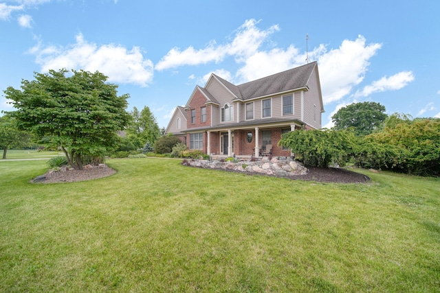 874 Pinecrest, Dexter, MI 48130 - view of front of house featuring a front lawn, brick siding, and covered porch