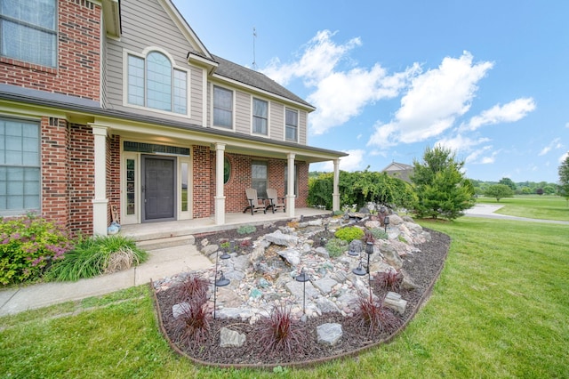 874 Pinecrest, Dexter, MI 48130 - exterior space featuring brick siding, a yard, and covered porch