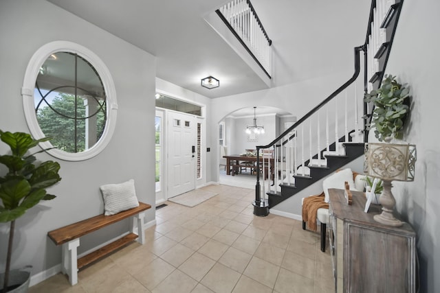 874 Pinecrest, Dexter, MI 48130 - foyer entrance with stairway, arched walkways, light tile patterned floors, and a chandelier