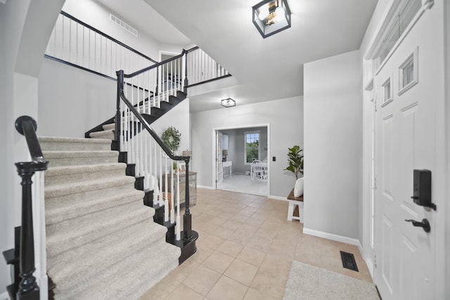 874 Pinecrest, Dexter, MI 48130 - entryway featuring stairway, light tile patterned floors, arched walkways, and a high ceiling