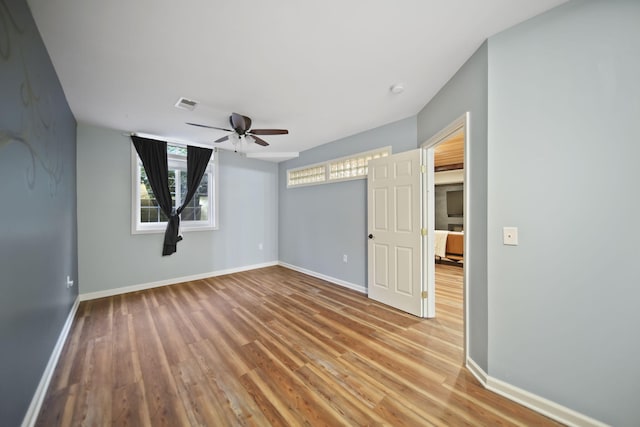 874 Pinecrest, Dexter, MI 48130 - unfurnished bedroom featuring multiple windows, wood finished floors, and a ceiling fan