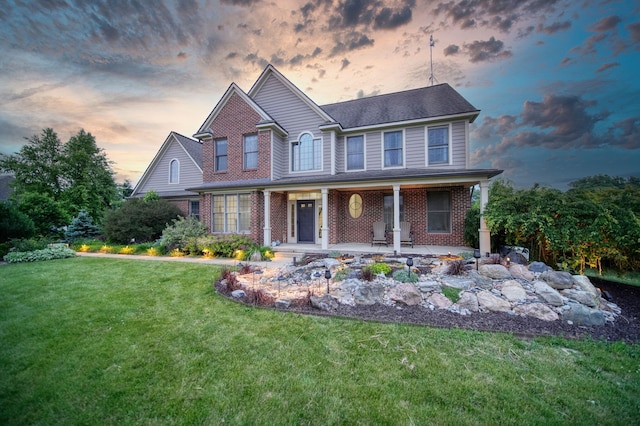 874 Pinecrest, Dexter, MI 48130 - view of front of home featuring brick siding, a front lawn, and covered porch