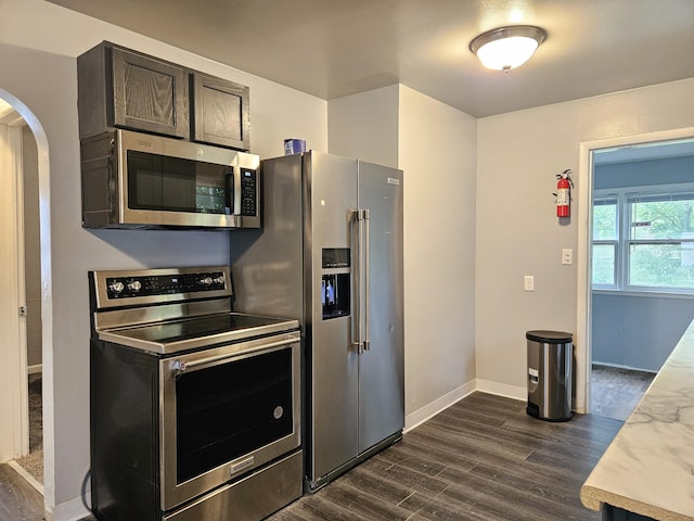 1406 Bixby Rd, Kalamazoo, MI 49048 - kitchen featuring appliances with stainless steel finishes, arched walkways, dark wood finished floors, and light countertops