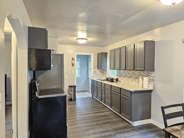 1406 Bixby Rd, Kalamazoo, MI 49048 - kitchen featuring dark wood-style flooring, light countertops, gray cabinetry, freestanding refrigerator, and decorative backsplash