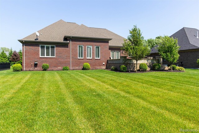 48913 Pinebrook Dr, Utica, MI 48315 - rear view of property with a yard, brick siding, and a shingled roof