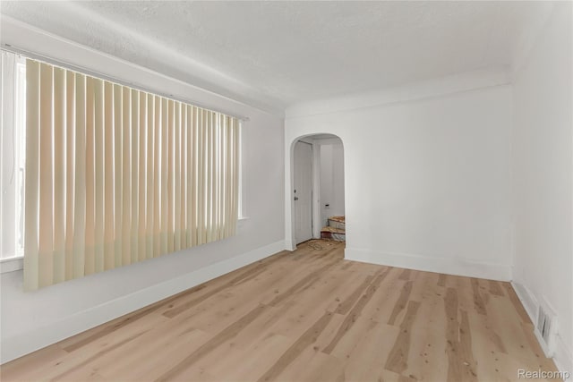 12719 Sussex St, Detroit, MI 48227 - empty room featuring arched walkways and wood finished floors