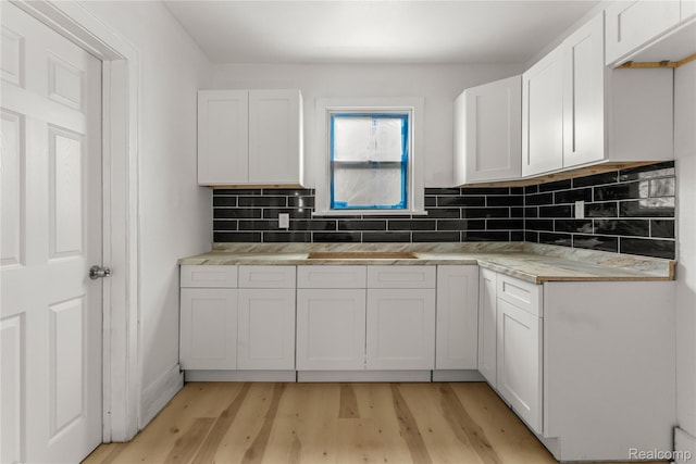 12719 Sussex St, Detroit, MI 48227 - kitchen featuring light wood-style flooring, tasteful backsplash, white cabinets, and light countertops