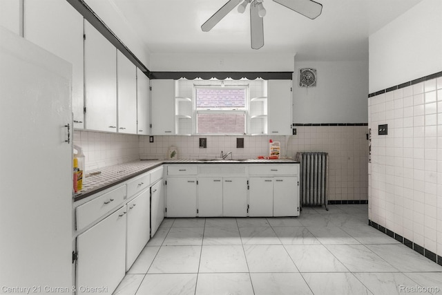 5527 Chalmers St, Detroit, MI 48213 - kitchen featuring radiator heating unit, ceiling fan, white cabinets, light countertops, and tile walls