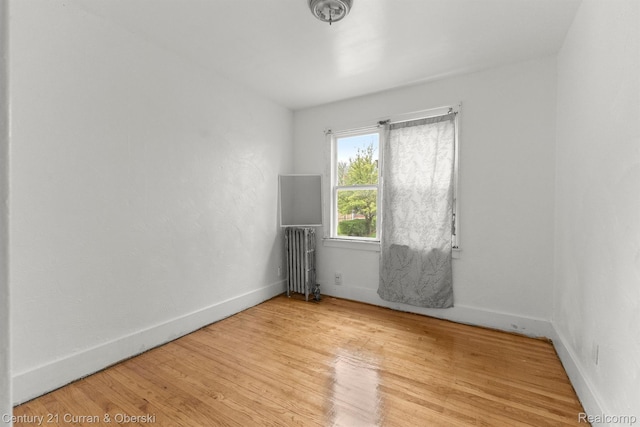 5527 Chalmers St, Detroit, MI 48213 - empty room featuring radiator heating unit and wood finished floors