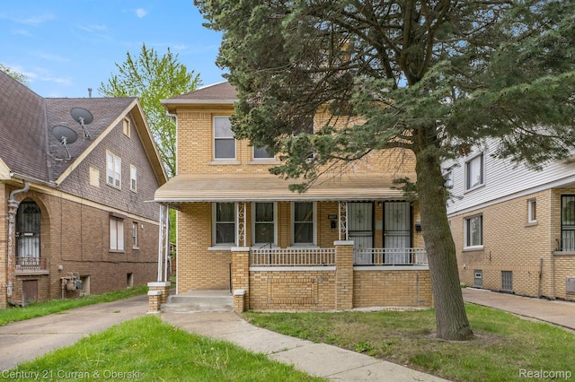 5527 Chalmers St, Detroit, MI 48213 - american foursquare style home featuring a porch, brick siding, roof with shingles, and a front lawn