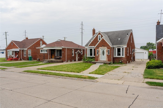 15648 Stricker Ave, Sterling Heights, MI 48021 - bungalow-style house featuring a detached garage, brick siding, an outbuilding, a front yard, and a chimney